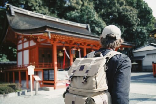 Photo by bobby hendry man wearing black top and backpack near orange structure