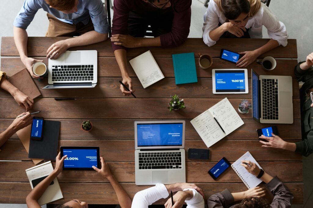 Over Tourism in Japan: What’s Happening and How You Can Help 3 Overhead view of a diverse team in a business meeting using laptops and tablets.
