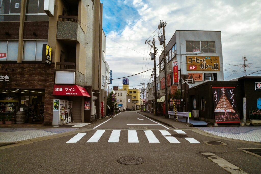 Japanese Cars vs American Cars: A Traveler's Eye-Opening Journey from Tokyo Streets to American Highways 3 Vibrant urban street in Japan with buildings and a zebra crossing in view.